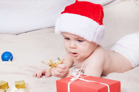 Beautiful little baby celebrates Christmas. New Year's holidays. Baby in Santa hatの写真素材