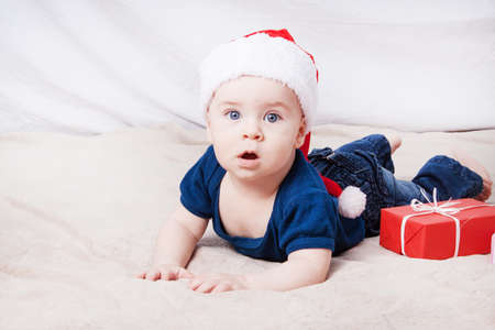 Beautiful little baby celebrates Christmas. New Year's holidays. Baby in Santa hatの写真素材