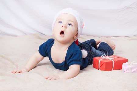 Beautiful little baby celebrates Christmas. New Year's holidays. Baby in Santa hatの写真素材