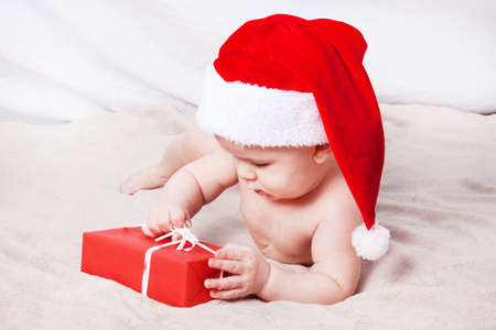 Beautiful little baby celebrates Christmas. New Year's holidays. Baby in Santa hatの写真素材