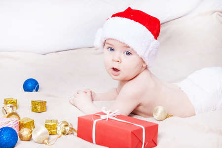Beautiful little baby celebrates Christmas. New Year's holidays. Baby in Santa hatの写真素材