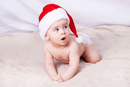 Beautiful little baby celebrates Christmas. New Year's holidays. Baby in Santa hatの写真素材