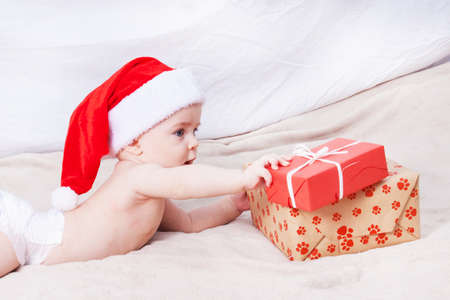 Beautiful little baby celebrates Christmas. New Year's holidays. Baby in Santa hatの写真素材
