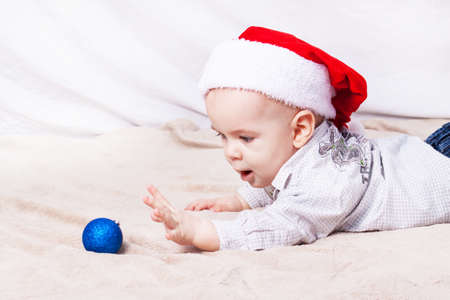 Beautiful little baby celebrates Christmas. New Year's holidays. Baby in Santa hatの写真素材