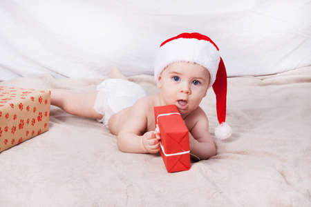 Beautiful little baby celebrates Christmas. New Year's holidays. Baby in Santa hatの写真素材