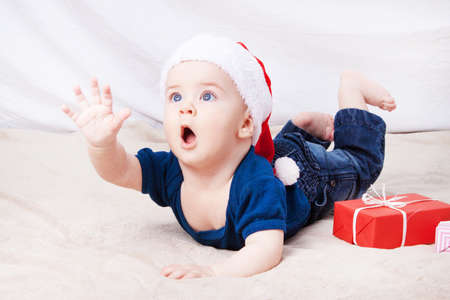 Beautiful little baby celebrates Christmas. New Year's holidays. Baby in Santa hatの写真素材