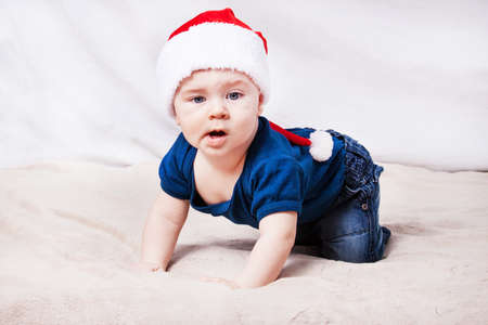 Beautiful little baby celebrates Christmas. New Year's holidays. Baby in Santa hatの写真素材