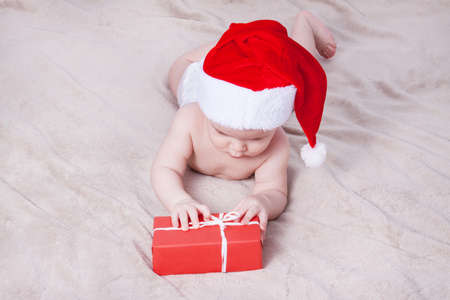 Beautiful little baby celebrates Christmas. New Year's holidays. Baby in Santa hatの写真素材