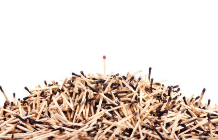 Burnt matches stack with burning match on white backgroundの写真素材