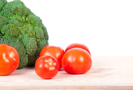 broccoli and tomatoes isolated on wooden tableの写真素材