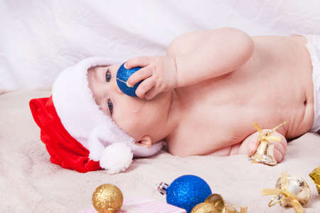 Beautiful little baby celebrates Christmas. New Year's holidays. Baby in Santa hatの写真素材