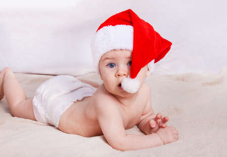 Beautiful little baby celebrates Christmas. New Year's holidays. Baby in Santa hatの写真素材
