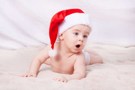 Beautiful little baby celebrates Christmas. New Year's holidays. Baby in Santa hatの写真素材