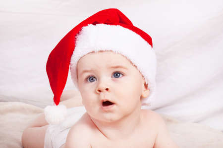 Beautiful little baby celebrates Christmas. New Year's holidays. Baby in Santa hatの写真素材