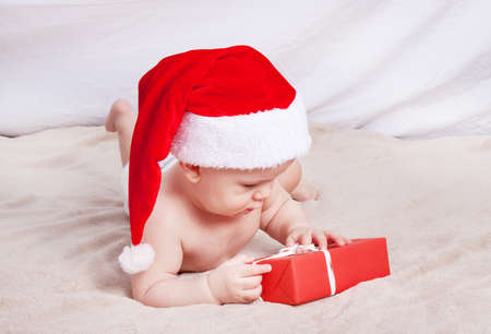 Beautiful little baby celebrates Christmas. New Year's holidays. Baby in Santa hatの写真素材