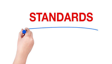 Standards word write on white background by woman hand holding highlighter pen