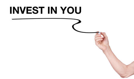 Invest in You word writting by men hand holding highlighter pen with line on white backgroundの写真素材