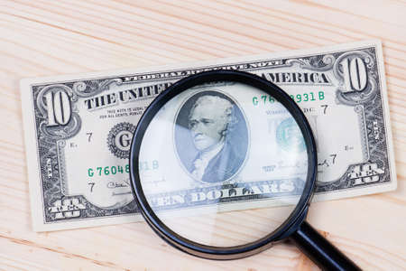 authentication of ten dollars banknote on wooden backgroundの写真素材