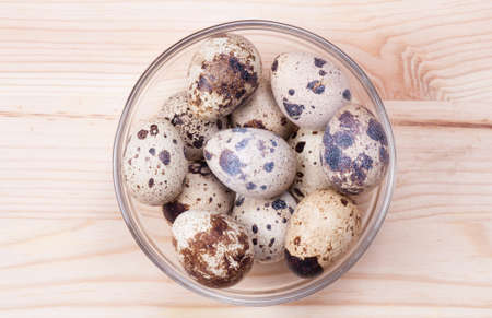quail eggs in a bowl of glass on boardsの写真素材