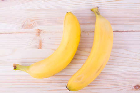 Ripe fresh bananas on wooden backgroundの写真素材