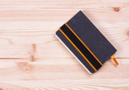 Black notebook on a wooden board
