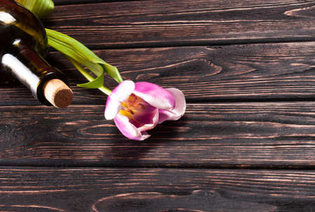 Tulip and wine on wood background