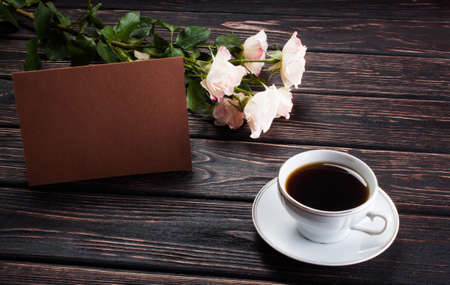 Roses and card on wood background