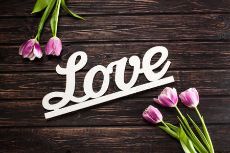 Inscription love and tulip on wood backgroundの写真素材