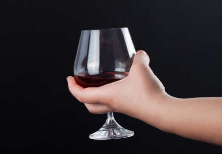 Woman holding a wine glass on black backgroundの写真素材