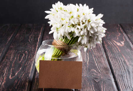 bouquet of snowdrops in vase on wooden boardsの写真素材