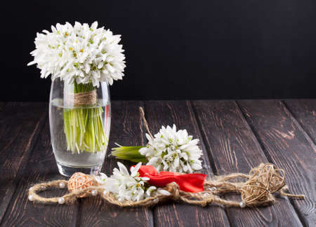 bouquet of snowdrops in vase on wooden boardsの写真素材