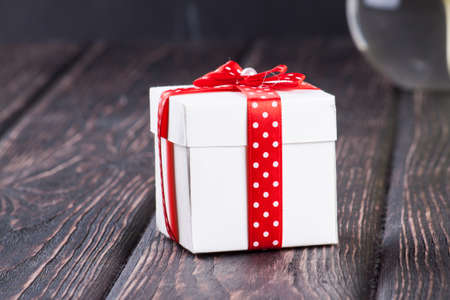bouquet of snowdrops in vase and gift box on wooden boards