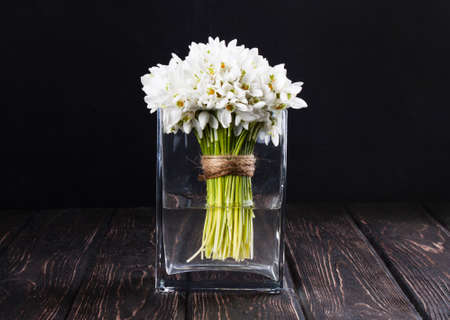 bouquet of snowdrops in vase on wooden boardsの写真素材