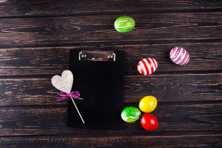 Easter eggs with clipboard on rustic wooden backgroundの写真素材