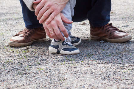 Two pairs of legs, child and mother or father with colorful snickersの写真素材