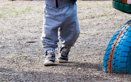 Two pairs of legs, child and mother or father with colorful snickersの写真素材