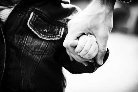 Black and white photo. Trust family hands of child son and father on nature outdoorの写真素材