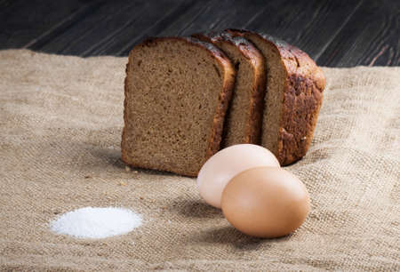 Homemade whole bread and flour on wooden backgroundの写真素材