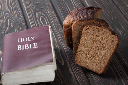 Bible and bread on a wooden board