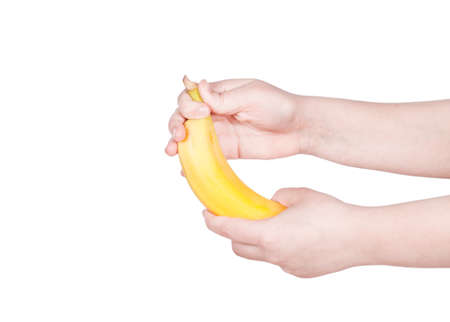 female hand holding a banana on a white backgroundの写真素材