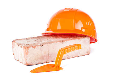 Orange Construction Helmet with brick isolated on white backgroundの写真素材