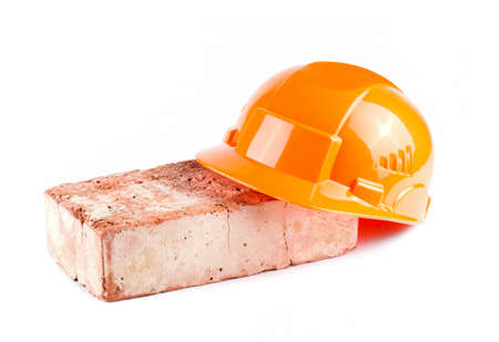 Orange Construction Helmet with brick isolated on white backgroundの写真素材