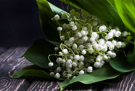 Beautiful floral frame with lilies of the valley flowers on old wooden table.の写真素材