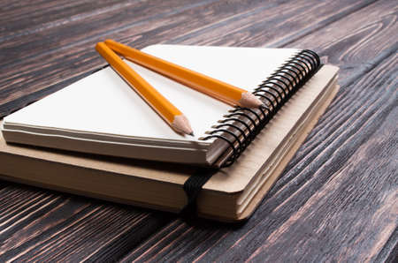 notepads with pencil on a wooden board
