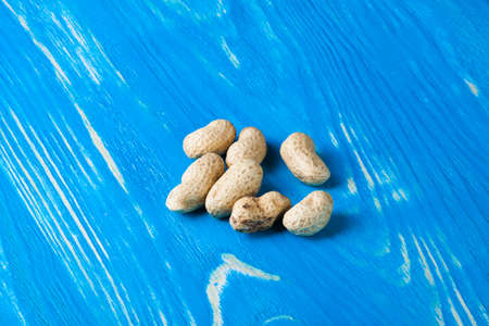 Peanuts in the shell on wood desk