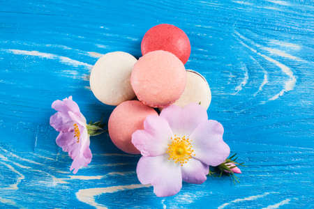 Multicolored macaroon on blue boards with flower.の写真素材