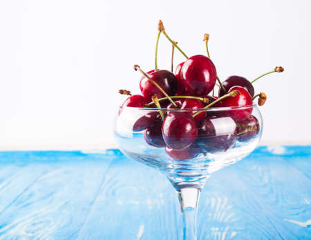 Cherry in vase on wood board. Fresh cherryの写真素材