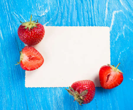 Ripe fresh strawberry with card on a wood desk. Nature backgroundの写真素材