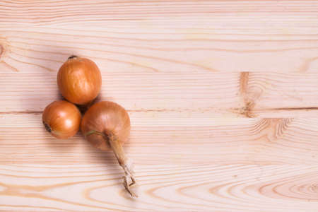 Dried onion on wood background.