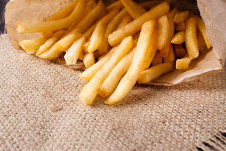 pile of appetizing french fries on sack cloth